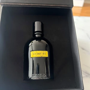 Svart parfymflaska från Once Perfume med etiketten Berries - Elegant parfymflaska i svart glas från Once Perfume Tillverkad i Italien med en gul etikett där det står 'Berries'. Flaskan har rund form och svart lock. Perfekt för dig som gillar stilrena och moderna dofter. kvar i flaskan nästan 99 % 