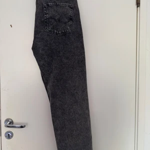 Grå loose fit jeans från Jack & Jones - Säljer ett par grå loose fit jeans från Jack & Jones i modellen Loose Eddie. Jeansen har klassisk femficksdesign, normalhög midja och raka ben. Perfekta för en avslappnad stil och passar till det mesta.
