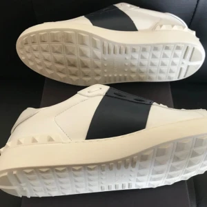 Valentino Garavani Open | ev byte - Säljer ett par vita Valentino Garavani Open sneakers med bred svart rem över mitten. Endast använda inomhus så dom är som nya storlek 40 | kan bytas mot förlag 