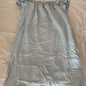 Ljusblå axelbandslös klänning - Söt ljusblå klänning med axelbandslös design. Klänningen har en rak passform och är använd fåtal gånger.