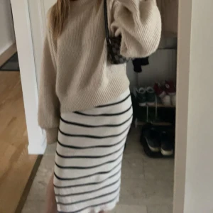 Vit ribbad kjol med svarta ränder från H&M Divided - Säljer en vit ribbad kjol från H&M Divided med svarta horisontella ränder. Kjolen är midilång och har en stretchig, kroppsnära passform med en slit. Perfekt att styla med en stickad tröja eller en enkel topp. Öppen för prisförslag🥰