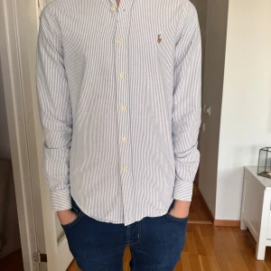 Ralph lauren skjorta  - Säljer en Ralph lauren Oxford skjorta | storlek S | modell slim fit | nypris 1500 kr | mitt pris 499 | skick 8/10 | finns en liten orange fläck där bak som ni ser på bild 4, men inget jätte märkvärdigt. Perfekt för sommaren. Hör av er vid fler funderingar | Digitalt kvitto nedkommer 
