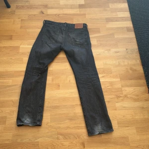 Levi's 501 svarta jeans - Säljer ett par klassiska svarta Levi's 501 jeans med raka ben och femficksmodell. Jeansen är i denim och har knappgylf samt den ikoniska läderpatchen bak i midjan. Perfekta för en tidlös och avslappnad stil. Nypris för dessa runt 1199, mit är pris 349! Byxorna har inte andvänts mycket då dem bara har lite slitmärken där bak, längst ner vilket jag bara tycker gör det snyggt! Pris går att diskuteras! Hör av er vid minsta lilla fundering🤗