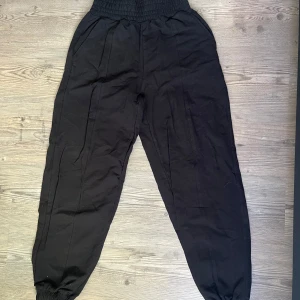 Svarta mjukisbyxor med hög midja - Svarta mjukisbyxor med bred resår i midjan och vid benslut samt söm detalj på benen från bershka, storlek S, aldrig använd