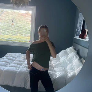 Mörkgrön croppad t-shirt - Säljer en mörkgrön croppad t-shirt med kort ärm och avslappnad passform. Perfekt för en trendig och bekväm stil. Passar till både jeans och kjol.