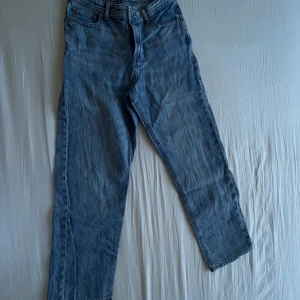 Blå jeans från Jack & Jones - Klassiska blå jeans från Jack & Jones med rak passform och normal midja. Jeansen har fem fickor och stängs med dragkedja och knapp. Perfekta till vardags och enkla att matcha med olika stilar.