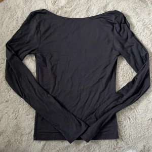 Mörkgrå långärmad topp med öppen rygg från Gina Tricot - Säljer en mörkgrå långärmad topp från Gina Tricot med djup, öppen rygg. Toppen är tight och har en enkel, stilren design som passar perfekt till många olika outfits. Passar xs-s. Supersöt! Skriv vid frågor eller funderingar.😋😍😇😝