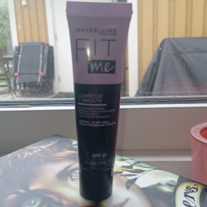 Maybelline Fit Me Luminous + Smooth Foundation SPF 20 - Maybelline Fit Me Luminous + Smooth Foundation i tub, 30 ml. Ger en återfuktande finish med vitamin E och SPF 20. Passar normal till torr hud. Tuben är svart och lila med skruvkork och smal applikator.