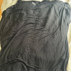 Svart t-shirt från Black Premium by EMP - Svart t-shirt från Black Premium by EMP i klassisk modell. T-shirten har rund halsringning och är tillverkad i mjukt material som passar perfekt till vardags. Enkel och stilren design utan tryck eller mönster.