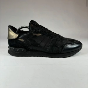 Svarta sneakers: Valentino Rockrunners - Säljer ett par svarta Valentino rockrunners. Storlek 42. Mycket bra skick, endast lite slitage i hälkappan. Självklart äkta vilket syns på bild fyra vid sömmen. Tveka inte att skriva vid frågor. 