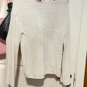 Vit stickad tröja från Editkted - Säljer en vit stickad tröja från Editkted. Tröjan har lång ärm, rak passform och är tillverkad i ett luftigt stickat material. Perfekt att styla med både jeans och kjol. Superenkel och snygg baströja!