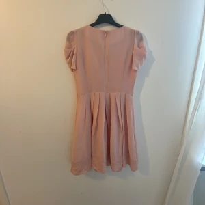 Rosa klänning  - En rosa klänning, jag är 157 och klänningen går lite under mina knän. Jag har haft på mig den bara 1 gång den är typ beige rosa mer rosa än beige.