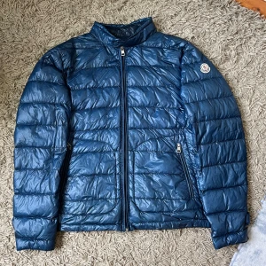 Blå Moncler Acorus Jacka - Hej! Säljer nu min Moncler Acorus jacka i mellanblå färg. Jackan är i bra skick och är perfekt som en tunnare jacka till hösten och våren. Jackan är 100% äkta, jag har köpt den från en pålitlig återförsäljare. Vid tveksamheter kan vi lösa äkthetskontroll! Size 4, passar M/L. Vid frågor eller funderingar är det bara att skriva!! // Oskar