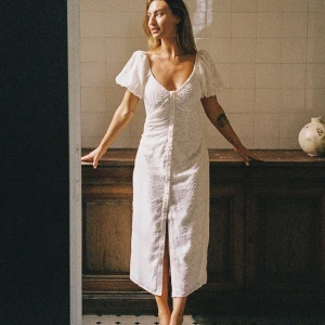 Vit omlottklänning med puffärm - Superfin vit klänning med puffiga kortärmar, v-ringning och knappar framtill. Väldigt snygg passform och är perfekt för sommarens alla tillfällen. Endast använd 1 gång förra året 