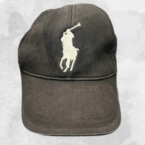 Ralph Lauren Keps Svart - Ralph Lauren Keps Svart i använt men fint skick. Inga skador på kepsen! Hör av dig vid frågor eller funderingar, mvh Oliver.