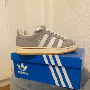 Adidas campus 00s grey  - Säljer ett par gråa adidas campus 00s i storlek 40, kartong kommer med fast denna kartongen är från ett par svarta campus! Skorna är använda i ca 4 dagar, det var inte min storlek därför säljer jag dem!   Skicket på skorna är typ som ny!  Säljer skorna för 1000kr + frakt!