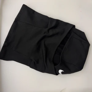 Nike Pro svarta mask  - Svarta Nike Pro shorts i tight modell, perfekta för träning. De är tillverkade i ett stretchigt syntetmaterial som andas och har en hög midja för extra stöd. Klassisk Nike Swoosh-logga framtill och Nike Pro-märke bak. Snygga och funktionella för gymmet eller löprundan.