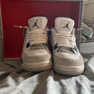 Nike Air Jordan 4 Retro White/Black - Säljer ett par Nike Air Jordan 4 Retro i färgerna vit, svart och grå. Klassisk siluett med meshpaneler, skinn och snygga detaljer. Ikonisk Jumpman-logga på plösen och hälen. Perfekta för dig som vill sticka ut med en tidlös sneaker. Kan diskutera pris 