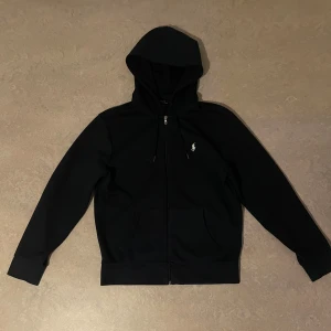 Svart mörkblå från Ralph Lauren - Mörkblå hoodie från Ralph Lauren med dragkedja och huva. I Bra skick. Köptes för 2099kr.