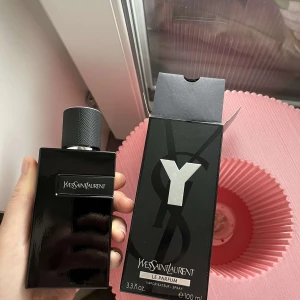 Yves Saint Laurent Y Le Parfum 100ml - Y Le Parfum från Yves Saint Laurent är en elegant herrdoft i en stilren svart glasflaska med silverdetaljer och tydlig YSL-logga på locket. Flaskan rymmer 100 ml och kommer i en svart kartong med stor Y-logga. Perfekt för dig som gillar exklusiva och moderna parfymer.