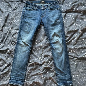Slim jeans från Jack & Jones, blå - Säljer ett par snygga slim fit jeans från Jack & Jones i klassisk blå tvätt. Modellen heter Glenn och har smal passform. Perfekta för dig som gillar en modern och stilren look.