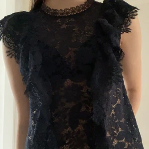 Mörkblå spets topp💙 - Söt mörkblå blus i spets från Zara med volangdetaljer på axlarna. Blusen är ärmlös och har ett blommigt spetsmönster! Den är strl Xs och är i mycket bra skick🌊