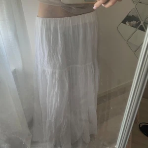 Vit långkjol från gina tricot - En fin vit långkjol från gina tricot i storlek M. Passar mig perfekt som vanligtvis har xs/s, jag är 170 och den går precis ner till marken. Nyskick!!🩷