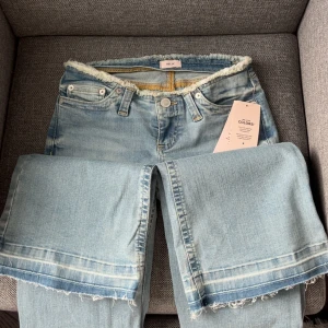  Ljusblå jeans från Nelly - Jättefina lågmidjade bootcut jeans från Nelly. Dem har etiketten kvar och är alltså i helt nytt skick. Jeansen har klassisk femficksdesign och bälteshällor. Perfekta för en avslappnad och trendig look.