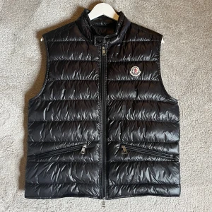 💫Moncler Gui väst💫 - Hej! Säljer nu min riktigt snygga och stilrena Moncler Gui väst. Storlek 2 vilket motsvarar S/M. Den är i jättefint skick förutom ett lagat pyttelitet hål, som ej syns eller som man tänker på (se bild 2). Perfekt nu till hösten. Nypris 9300:- Hör av er vid frågor eller funderingar💫🙌
