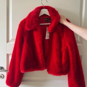 Röd pälsjacka från Zara XS - Säljer en sjukt snygg röd pälsjacka från Zara i storlek XS. Jackan har en fluffig och mjuk känsla, bred krage och långärmade ärmar. Perfekt för dig som vill sticka ut med en färgstark look. Materialet är polyester och jackan har en kort, loose passform. Den är helt ny och oanvänd ny pris är 849 jag säljer den för 500kr 