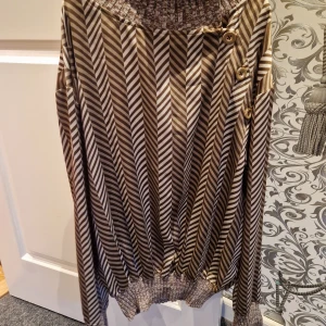 Brun och vit randig blus - En fin och elegant blus med mönster på. 