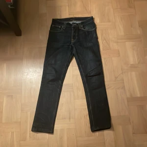 Nudie jeans  - Säljer nu ett par feta nudie jeans i mörkblå / svart färg. De är 30, 32 med rätt så bra skick,  De är perfekta till att ha en klassisk look till vardagen. Tveka inte på att höra av dig vid funderingar. 