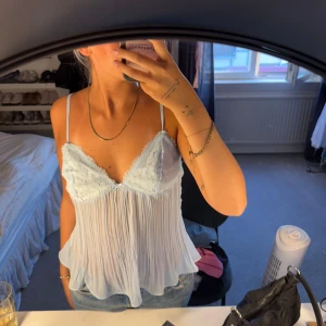 Ljusblå spetsig linnetopp från Princess Polly - Superfin ljusblå linnetopp från Princess Polly med tunna axelband och spetsdetaljer över bysten. Aldrig använt! Toppen har plisserad, flowy nederdel och v-ringning. Perfekt för dig som gillar romantisk och söt stil!