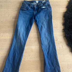 Lågmidjade jeans  - Helt nya!!                                                                         Snygga blå Molly jeans från l.t.b med låg midja och bootcut-ben. Klassisk femficksmodell med kontrastsömmar och detaljerade bakfickor. Jeansen är gjorda i mjukt denim-material och har en cool tvättad look. Perfekt för dig som gillar retrovibbar och avslappnad stil.