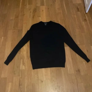 Svart och marinblå stickad tröja - Två stilrena stickade tröjor i svart och marinblått, perfekta för dig som gillar enkel och clean look. Båda har rund hals och långa ärmar, vilket gör dem grymma att matcha med jeans eller chinos. Materialet är mjukt och skönt, passar dig som vill ha en klassisk vibe.