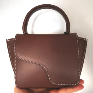 Brun väska från ATP Atelier med kontrastsömmar - MONTALCINO CANNELLA/CONTRAST STITCH LEATHER MINI HANDBAG  "Vardag" är Montalcinos mellannamn. Hon passar alla dina nödvändigheter, plus ett eftermiddagssnack. Hon kan bäras både på armen och över kroppen. H 11 cm W 18 cm D 6 cm