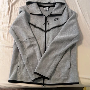 Grå Nike tech zip tröja - Säljer min Nike tech tröja storlek S som är i jätte bra skick, använd 7 gånger max. Köpt en större storlek nu så vill helst bli av med den här.