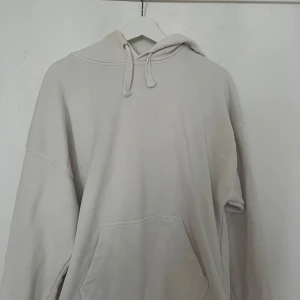Beige hoodie från H&M med huva - Säljer en enkel och clean beige hoodie från H&M i storlek M. Tröjan har huva med snörning och en stor magficka framtill. Perfekt för chill dagar och har en loose passform med långa ärmar. Materialet är mjuk bomull som känns skönt mot huden.