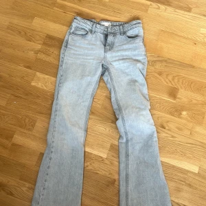 Lågmidjade Ljusgråa jeans från Gina Tricot - Snygga ljusgråa jeans från Gina Tricot med klassisk femficksdesign och dragkedja. Perfekta för en avslappnad stil. Har nån liten slitning på höger fickan som syns på bild 4 men ingenting som stör mig! Annars jättebra skick! 
