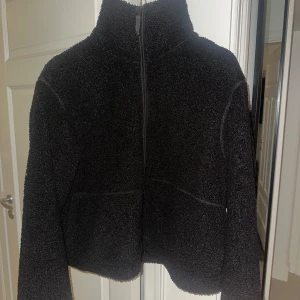 Svart teddyjacka H&M - Mysig svart teddyjacka med hög krage och dragkedja framtill från H&M. Jackan är perfekt för kyligare dagar. Den är långärmad och ger en trendig look. Teddyjackan är i xl men passar många beroende på hur man vill att den ska sitta (jag har normalt xs/s)🌸💞