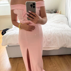 Ljus rosa balklänning/långklänning - Ljusrosa klänning i fint material. Off shoulder. Sitter perfekt på kroppen. Även stretchigt material. Har en slits på vänster sida/ben. Bra längd för mig som är 158/159/160. Mått och andra bilder kan skickas vid förfrågan. Rökfritt och djurfritt hem.  Fråga gärna vid fler frågor💕
