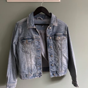 Ljusblå jeansjacka dam - Säljer en klassisk ljusblå jeansjacka med knappar framtill och två bröstfickor. Storlek 40.