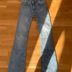 Blå jeans från 157 - Snygga blå jeans från 157 med klassisk femficksdesign och knappgylf. De har en bootcut-stil som ger en retro känsla. Perfekta för en avslappnad look. Nypris 400kr
