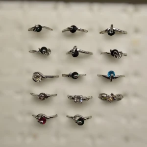 Kit med 14 ringar med sten - Behöver bli av med dessa så 10 kr st, ser gärna att du köper alla samtidigt. Notera att vissa på toppen har grön/blå sten fast ljuset gör så dem ser svarta ut. Material är jag osäker på någon metall/legering, enskilda storlekar får du fråga om (: