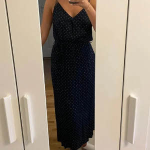 Mörkblå prickig långklänning - En marinblå prickig långklänning från Cubus som går att knyta i midjan! Därför passar den 34-38🥰 