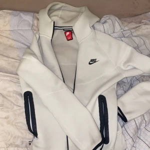 Nike tech fleece - Säljer en vit/biege tech fleece från Nike. Den är i mycket bra skick inga defekter alls. Materialet är inte förstört utan precis som en helt ny.
