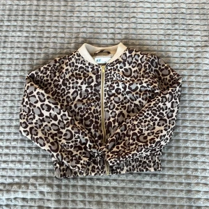 Leopardmönstrad bomberjacka från H&M - Säljer en cool leopardmönstrad bomberjacka från H&M. Jackan har dragkedja framtill och elastiska muddar vid ärmslut och nederkant. Perfekt för att ge din outfit en trendig touch 🐆