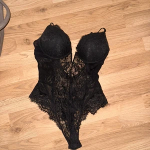 Svart spetskorsett från H&M - Säljer en elegant svart spetskorsett från H&M. Den har justerbara axelband och en vacker spetsdesign som ger en lyxig känsla. Perfekt för speciella tillfällen eller när du vill känna dig extra fin.