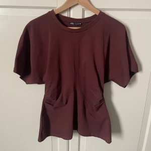 Topp - Vinröd topp från zara. T-shirt med drapering i sidan, använd en gång