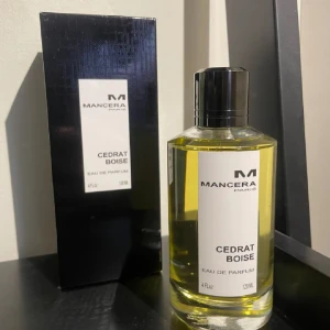 Cedrat Boise Mancera - Cedrat Boise från Mancera är en elegant Eau de Parfum med en fräsch och citrusaktig doft. Flaskan är genomskinlig med en svart kork och etikett, och rymmer 120 ml. Perfekt för den som söker en sofistikerad och uppfriskande doftupplevelse. Låda och kvitto finns, byten är intressant 
